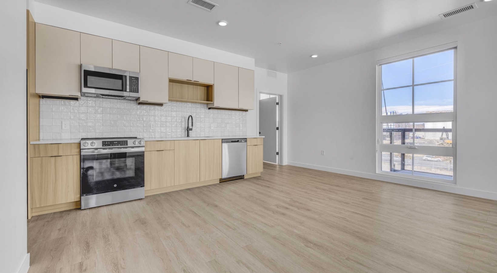 Refined spaces to match your style a kitchen and an empty living room with a laundry closet