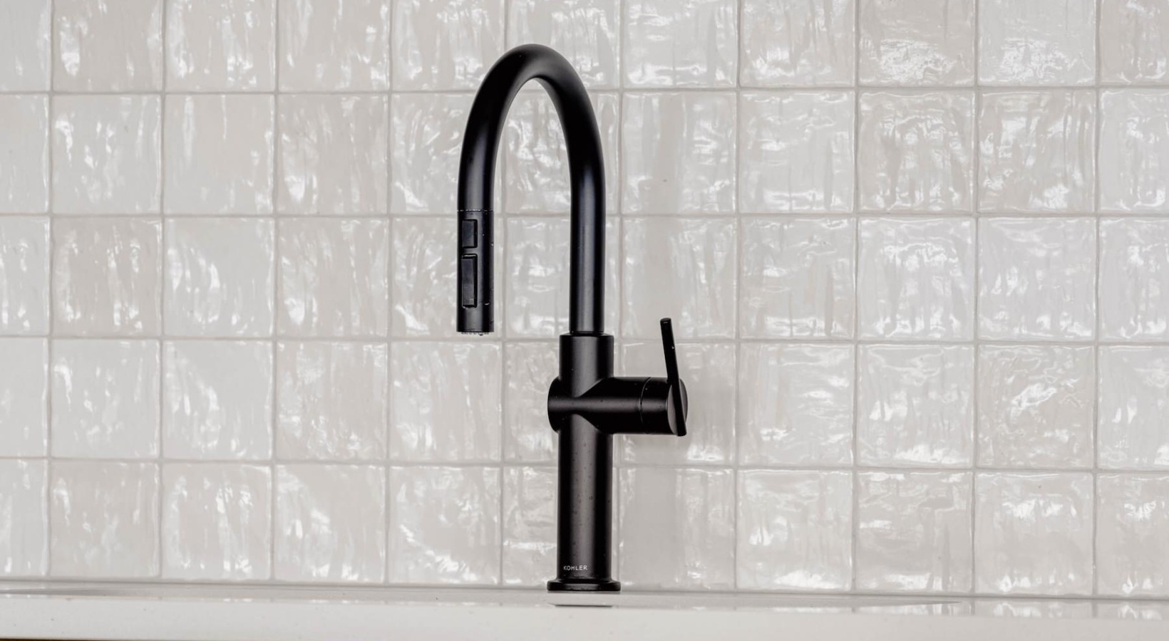 Beautiful kitchens with designer finishes a faucet with a white tile backsplash