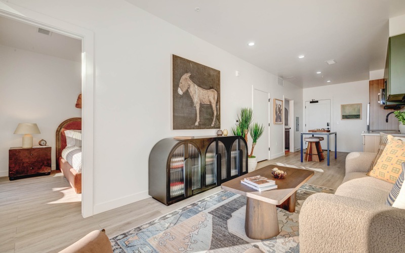Cozy living room area with tan couch and wood coffee table at Journeyman apartments in SLC.