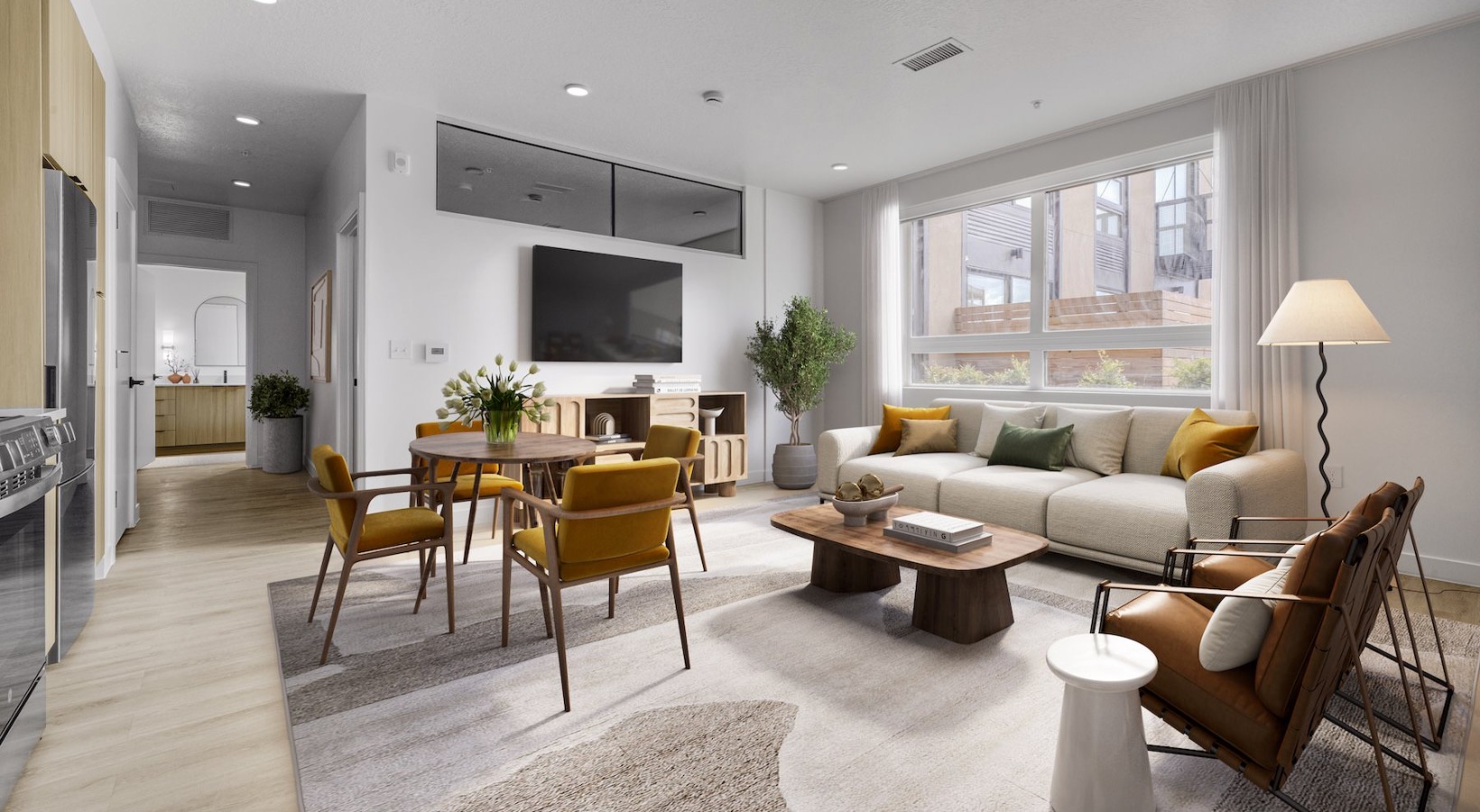 Spacious and well-lit living spaces a living room with a tv, a couch and chairs